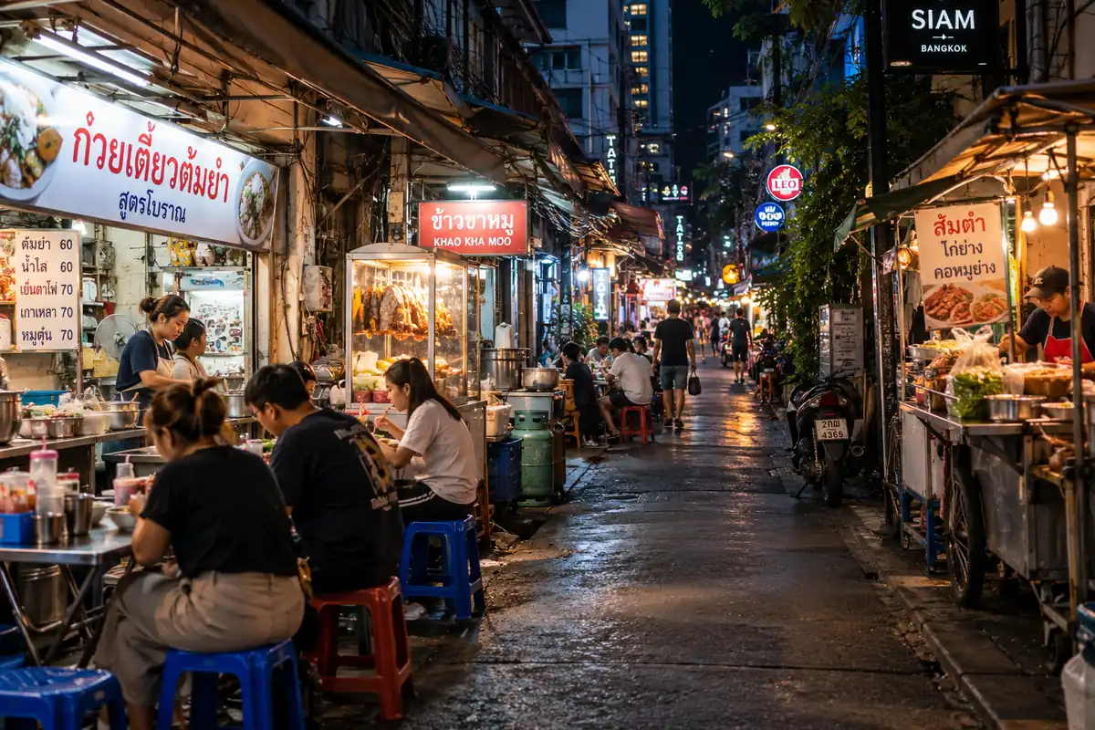 Ruelle de Bangkok le soir avec stands de street food, pour choisir où loger en Thaïlande