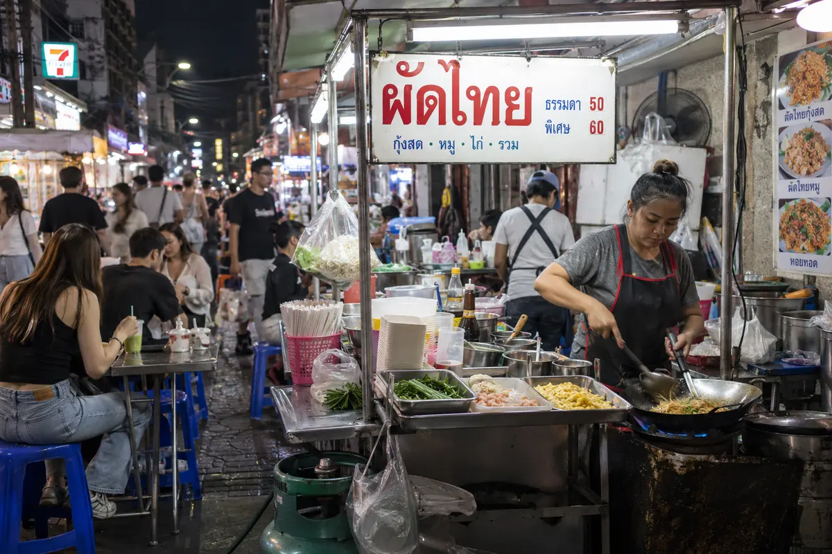 Stand de street food dans un marché de nuit à Bangkok, le meilleur allié d'un petit budget voyage Thaïlande
